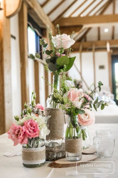 Jars and bottles of flowers displayed on a log slice