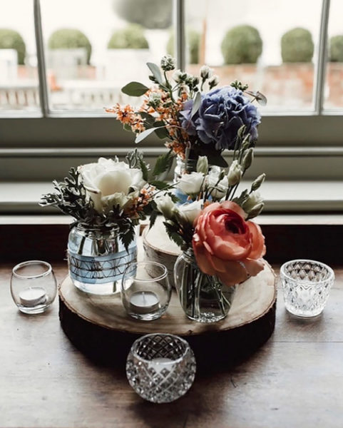 Jars of flowers displayed on a log slice