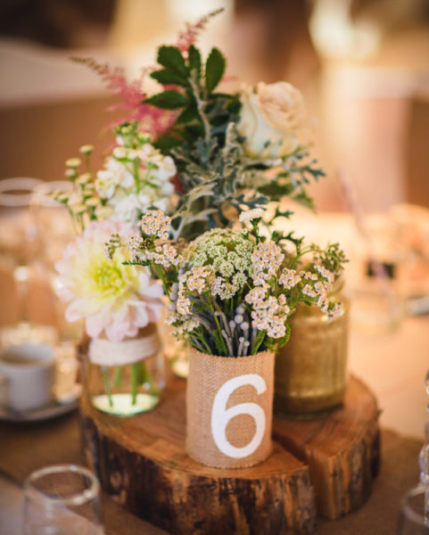 Jars and cans of flowers displayed on a log slice