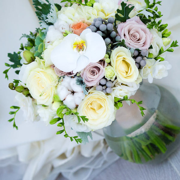White and pastel colour weddgin flower arrangement with berries, roses and feature orchids